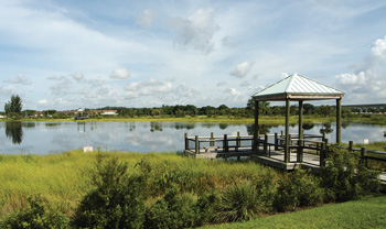 View of Sawgrass Sanctuary featuring a covered boardwalk overlooking a lake