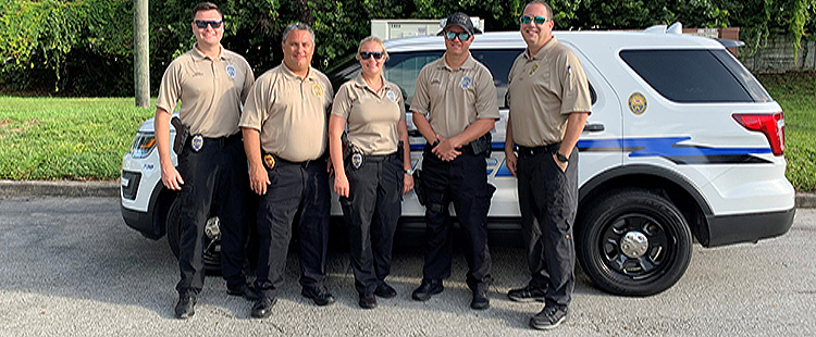 Group of ifficers standing by police car